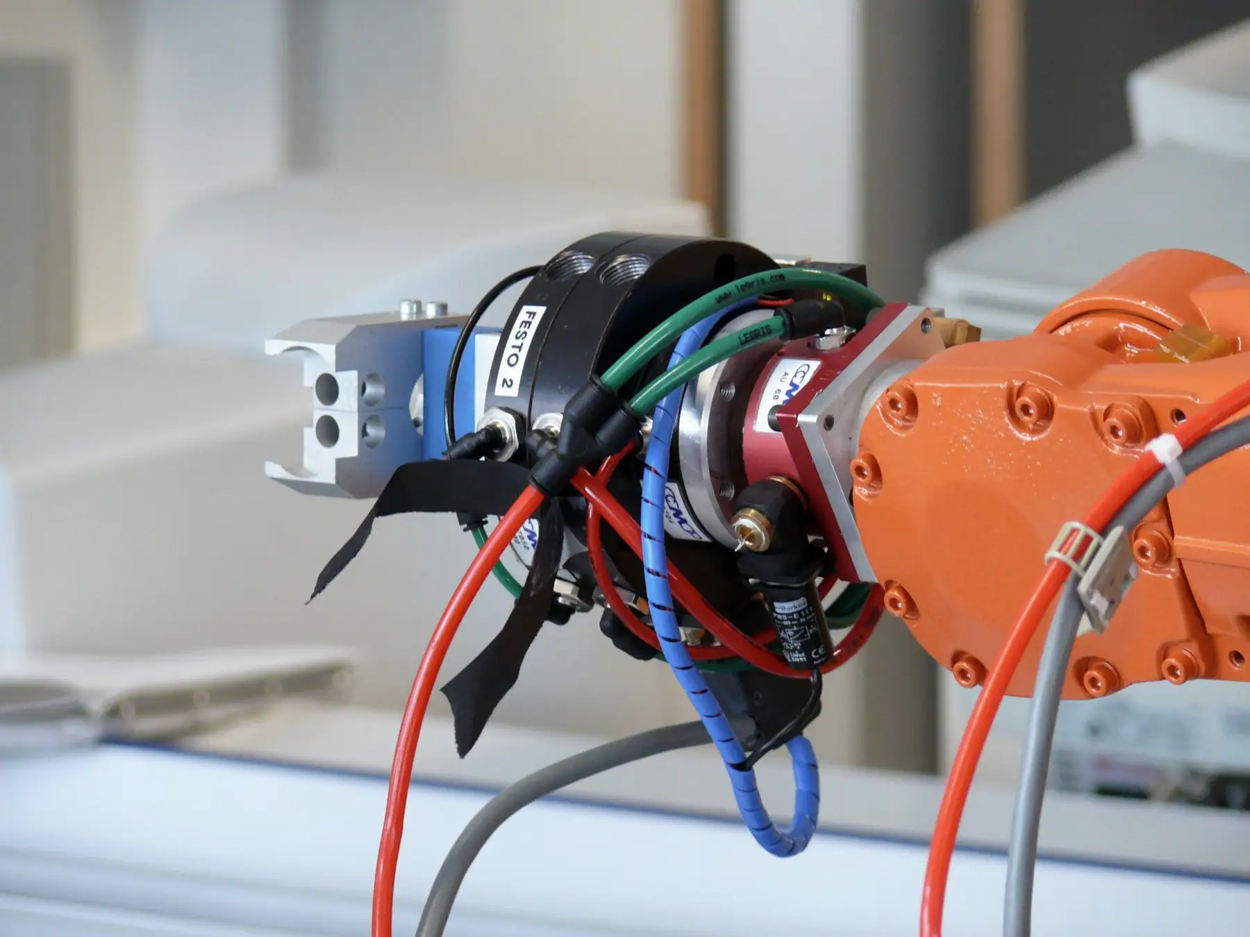 Turuncu robot bileğinde pnömatik paralel tutucu ve hava hortumları