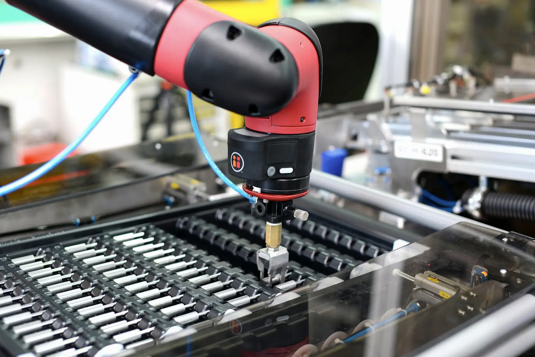 Kırmızı robot bileğinde vidalama ünitesi ve parça tepsisi